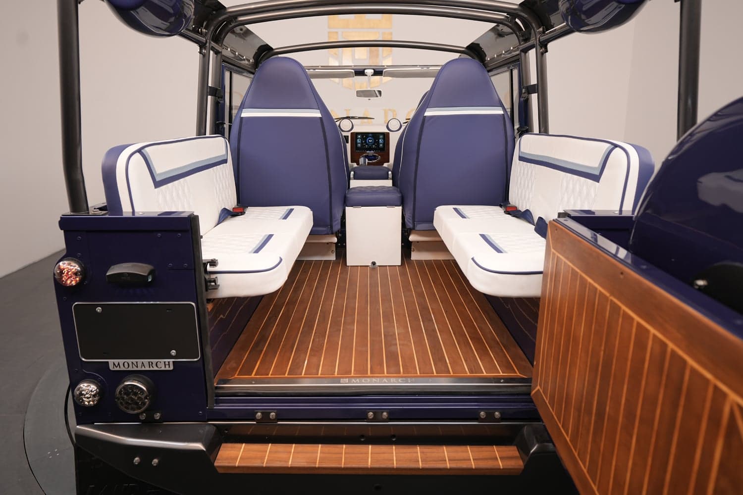 Interior of a custom Land Rover Defender featuring luxury seating and wood flooring