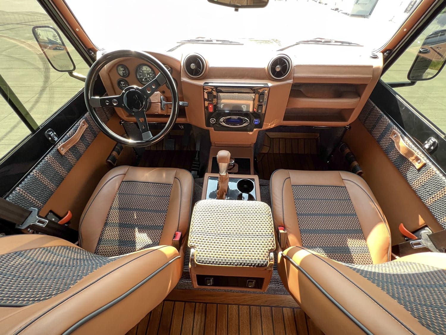 Interior Shot: Luxury Cabin Bespoke interior of a custom Land Rover Defender with premium leather seats and modern dashboard