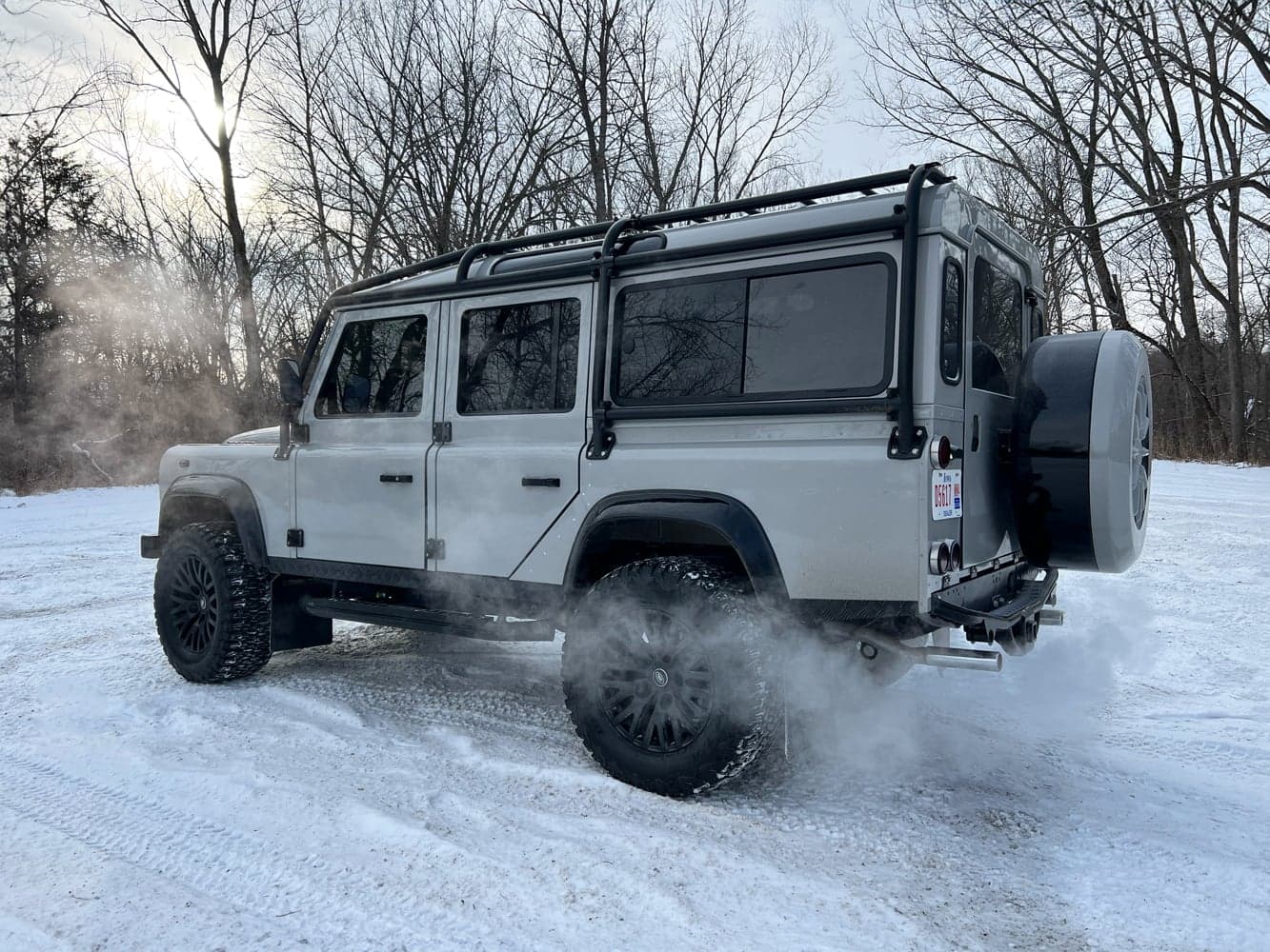 Action Shot: Bespoke Land Rover Defender in Snow Custom Land Rover Defender parked in snowy terrain with steam rising from the exhaust