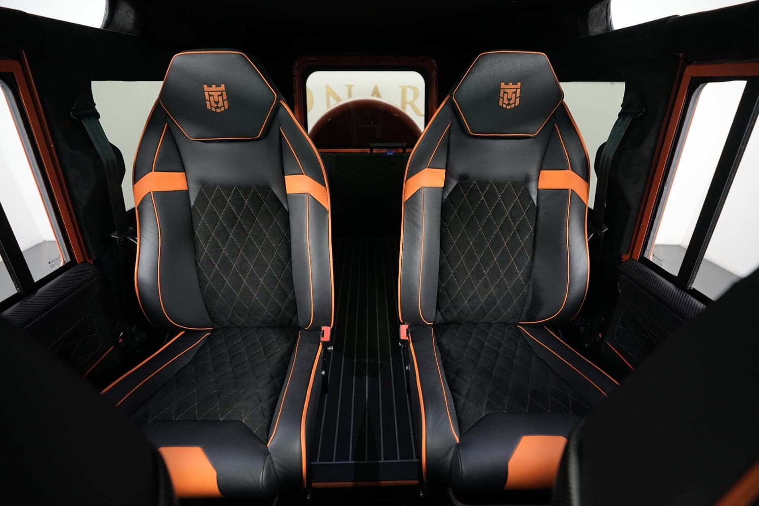 Interior Shot: Bespoke Seating Custom Land Rover Defender interior with luxury black and orange seats