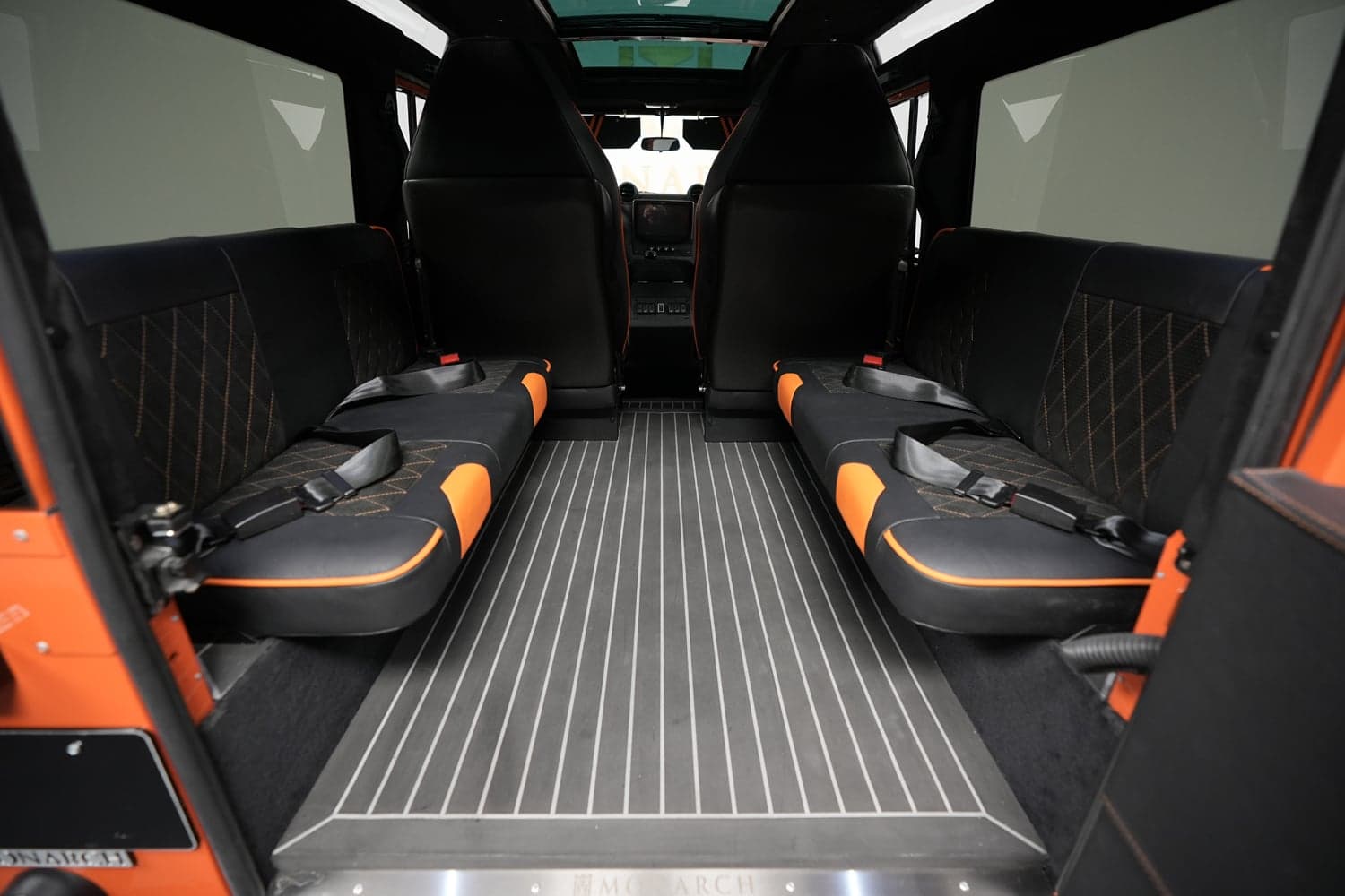 Interior Shot: Bespoke Seating Interior view showcasing bespoke seating in a custom Land Rover Defender with black and orange accents