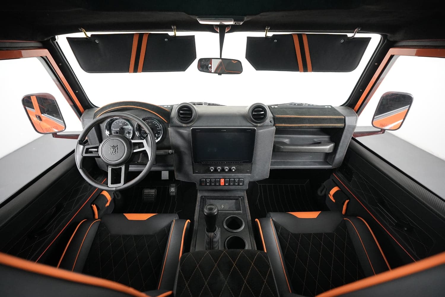 Interior Shot: Custom Luxury Cabin Bespoke Land Rover Defender interior featuring black and orange accents