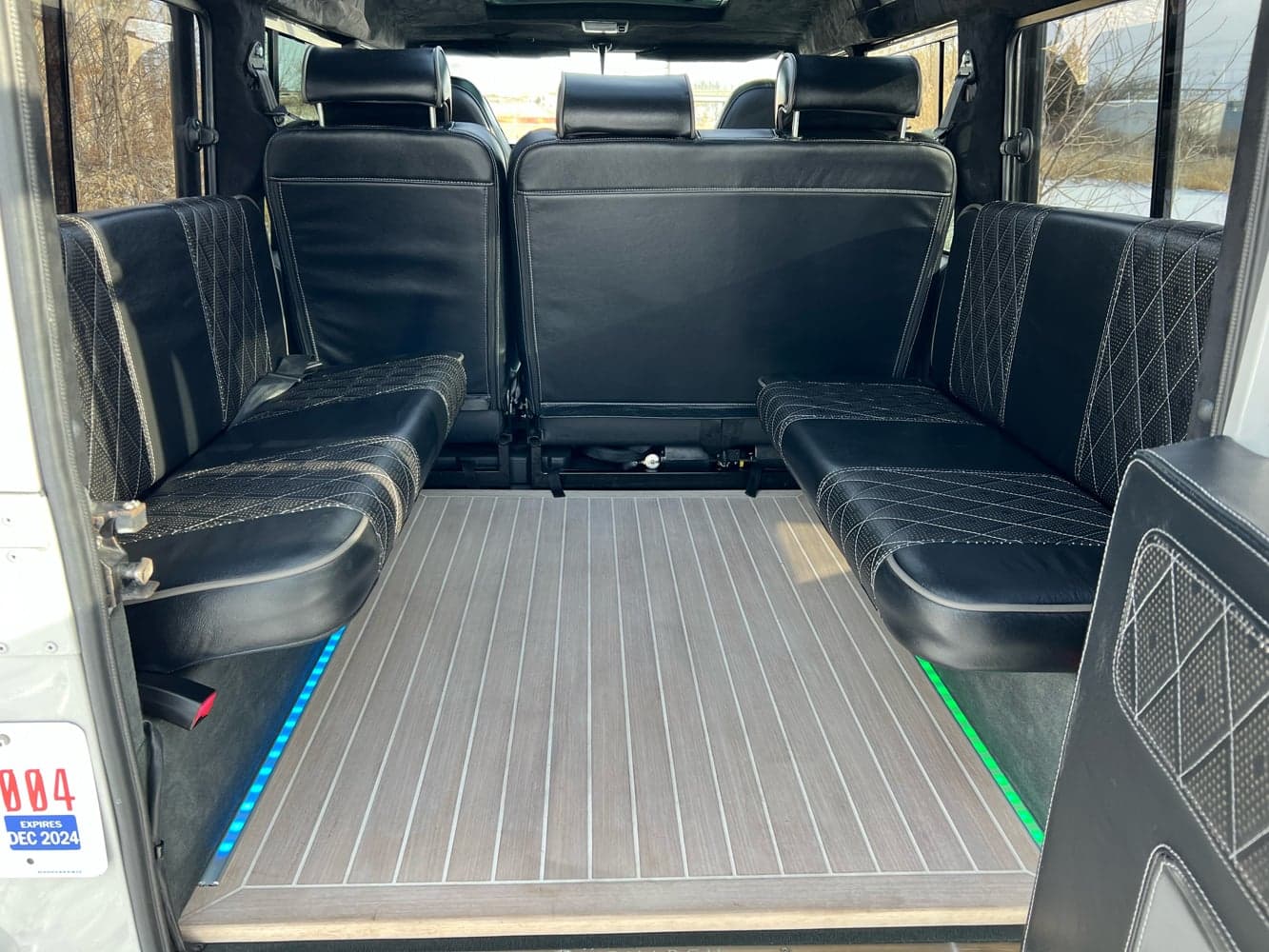 Interior Shot: Luxury Seating Interior view of a custom Land Rover Defender with luxurious black leather seating and wooden flooring