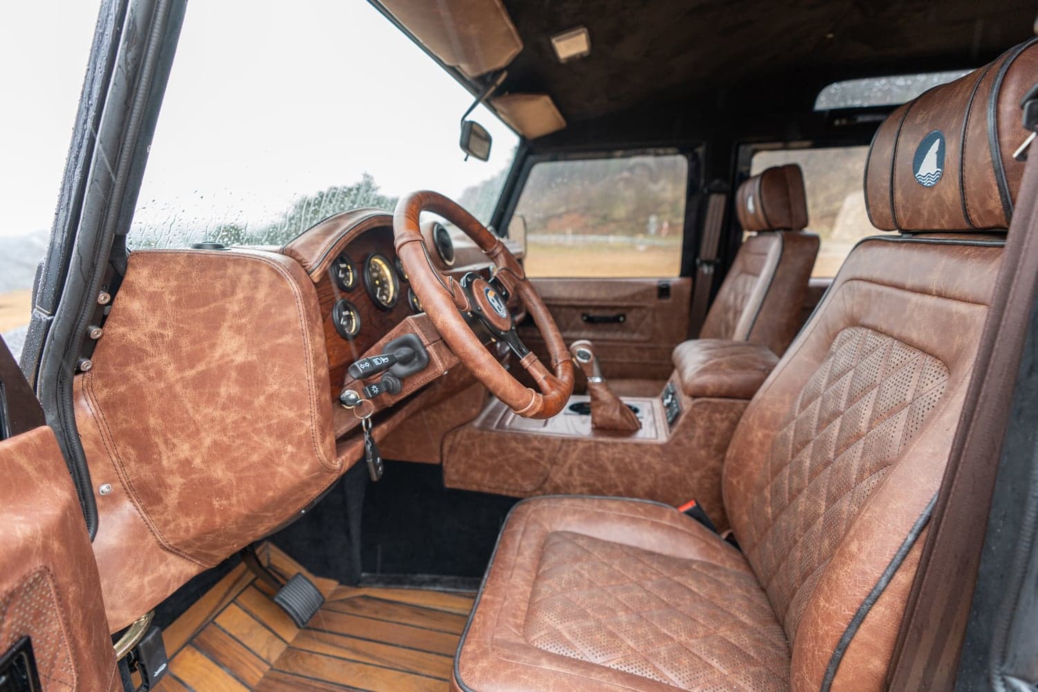 Interior Shot: Luxury Cabin Design Bespoke Land Rover Defender interior featuring premium brown leather upholstery and wooden accents