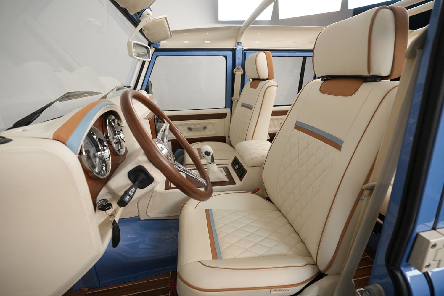 Interior Shot: Luxury Cabin Interior of a bespoke Land Rover Defender with cream leather seats and wooden accents