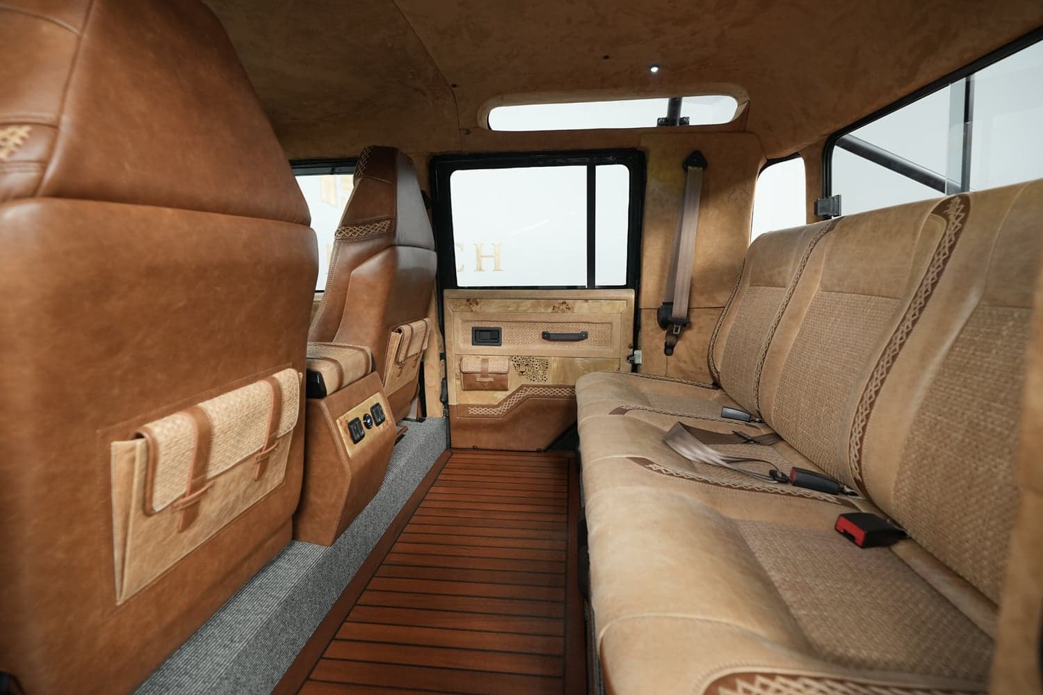 Interior Shot: Luxurious Cabin Design Luxurious interior of a custom Land Rover Defender with leather seating and wooden flooring