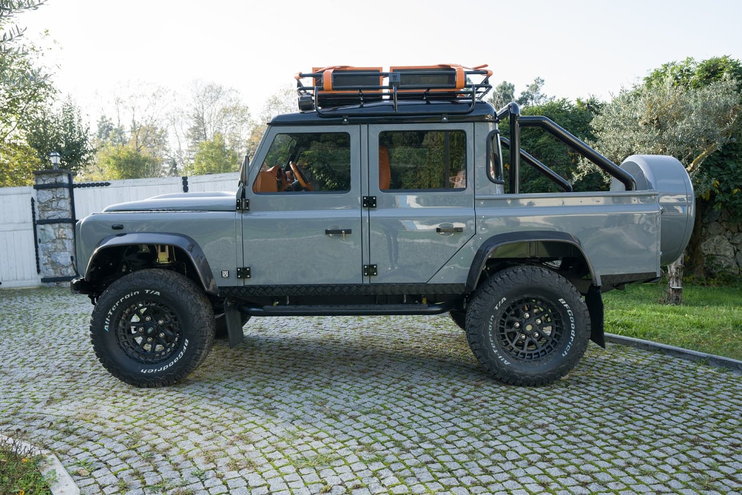 Side View: Bespoke Land Rover Defender Custom Land Rover Defender parked on cobblestone driveway