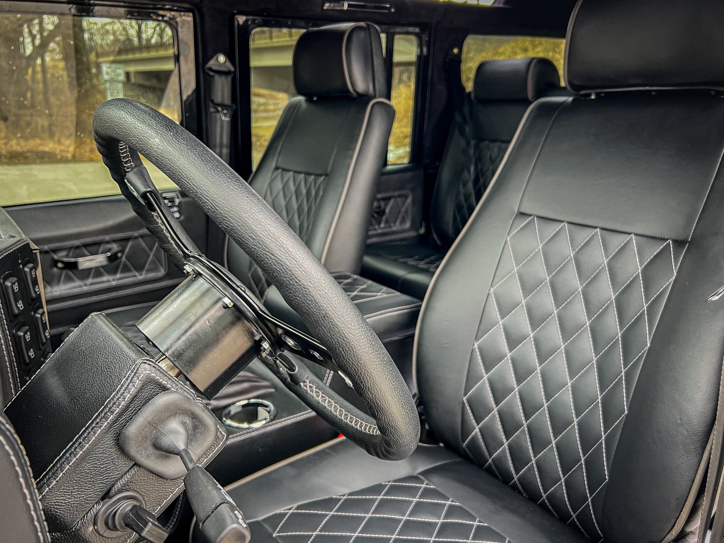 Interior Shot: Luxurious Black Leather Seats Interior view of a custom Land Rover Defender showcasing premium black leather seats with diamond stitching