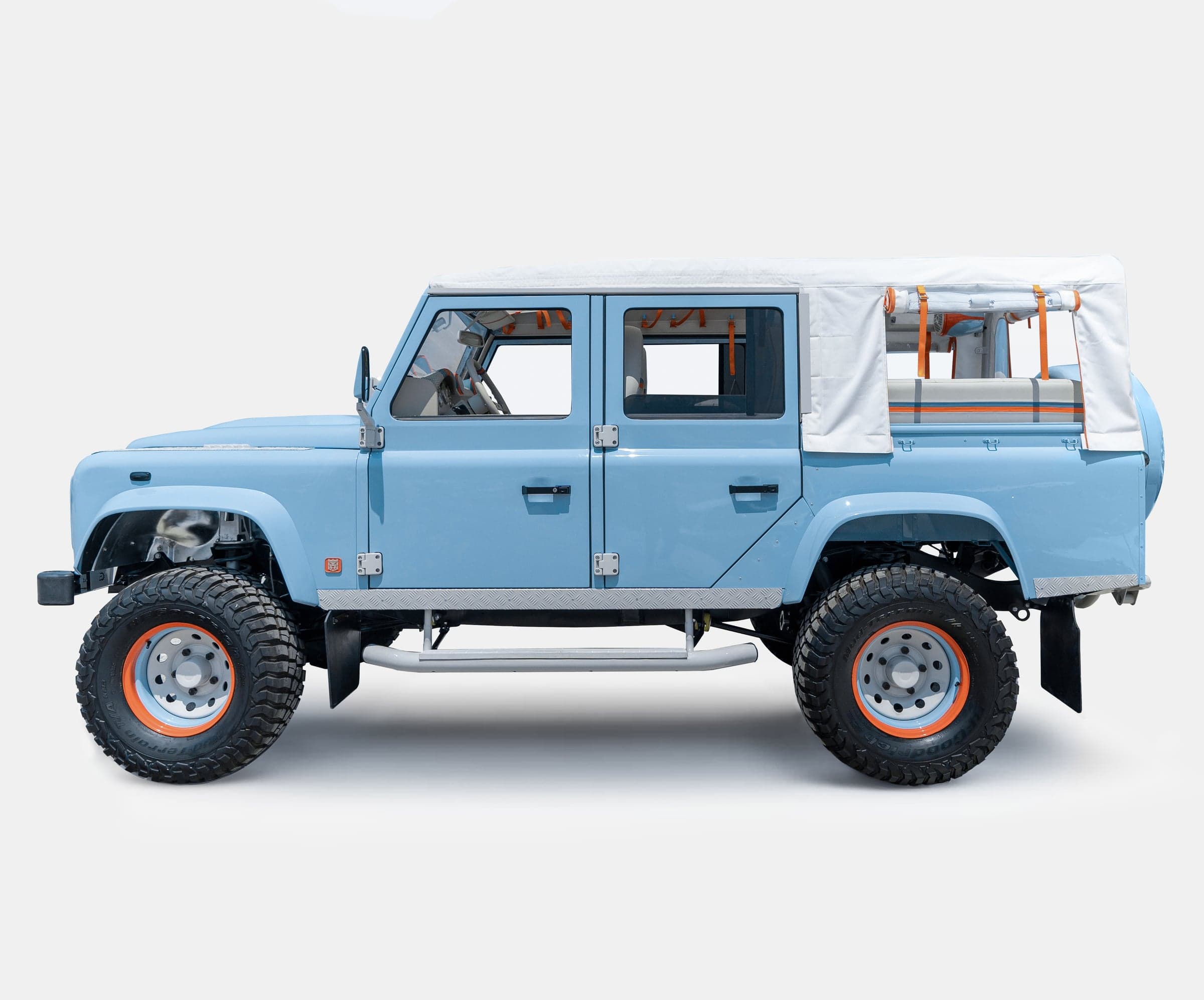 Side View: Bespoke Land Rover Defender Custom Land Rover Defender in light blue with a canvas top and off-road tires