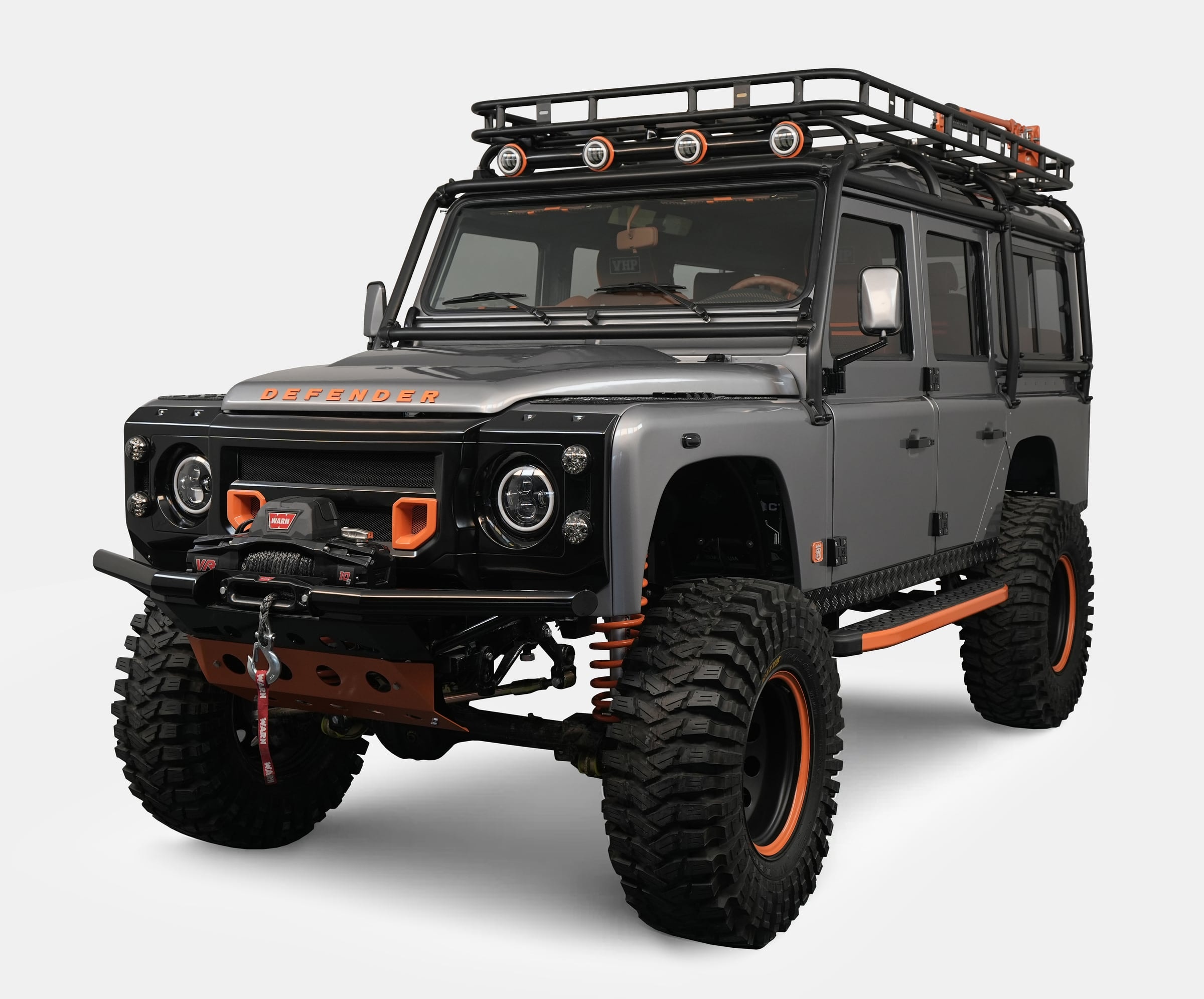 Front view of a bespoke Land Rover Defender with gray exterior and orange accents Front view of a bespoke Land Rover Defender with gray exterior and orange accents