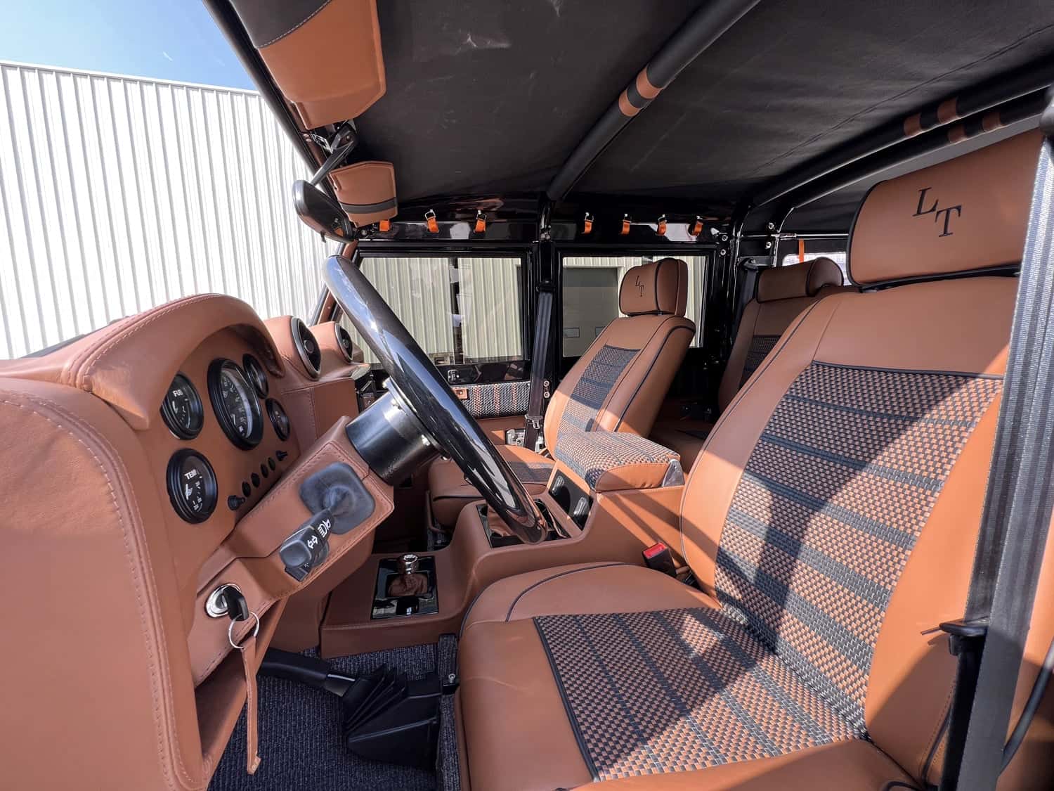 Interior view of a bespoke Land Rover Defender featuring premium tan leather seats and dashboard