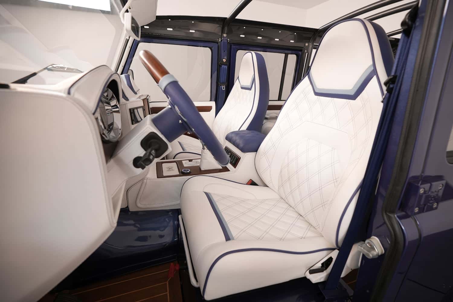 Luxury custom Land Rover Defender interior with white quilted leather seats and blue accents