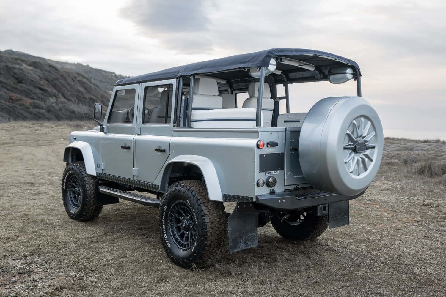 Rear view of a custom Land Rover Defender with a soft top and premium interior