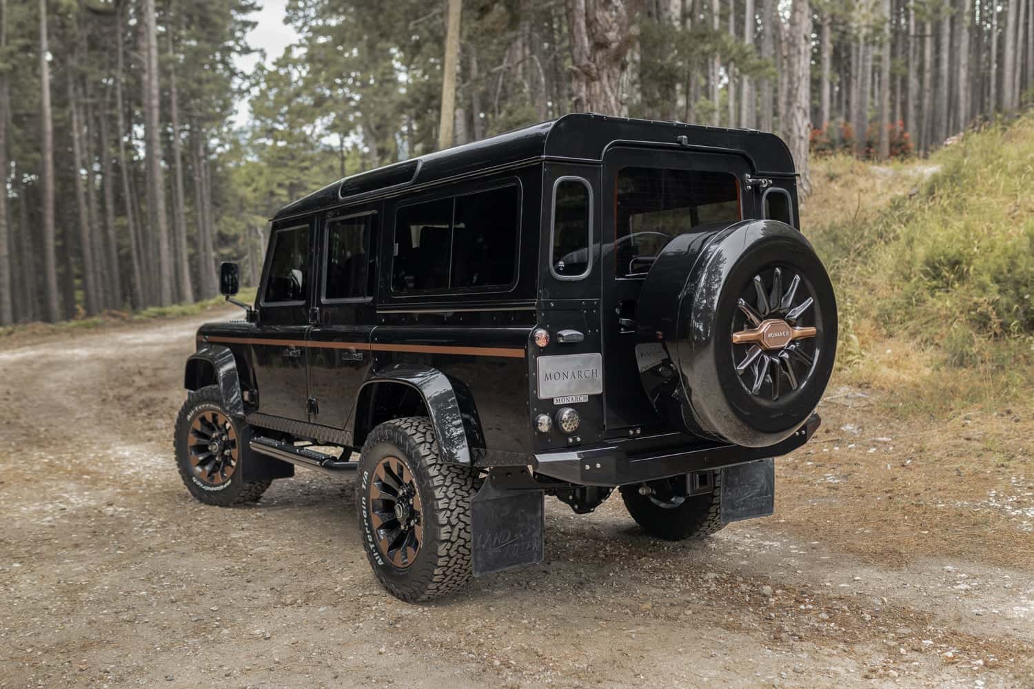 Rear view of a custom black Land Rover Defender with luxury modifications