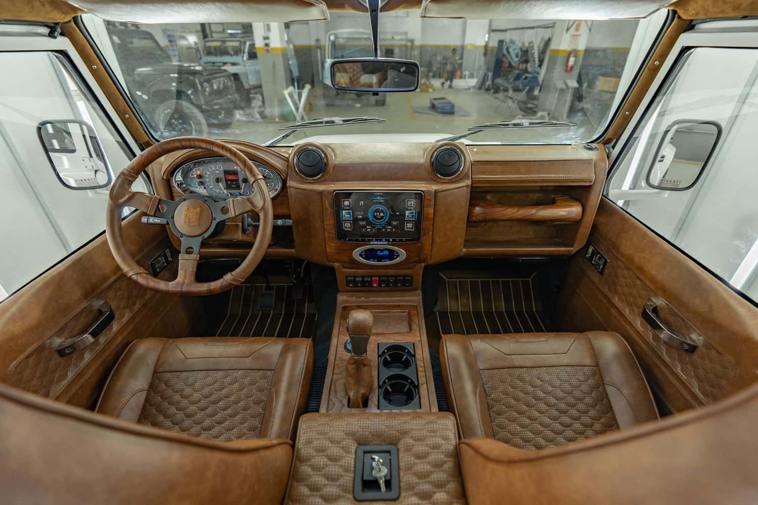Interior view of a custom Land Rover Defender with premium leather upholstery and modern dashboard features