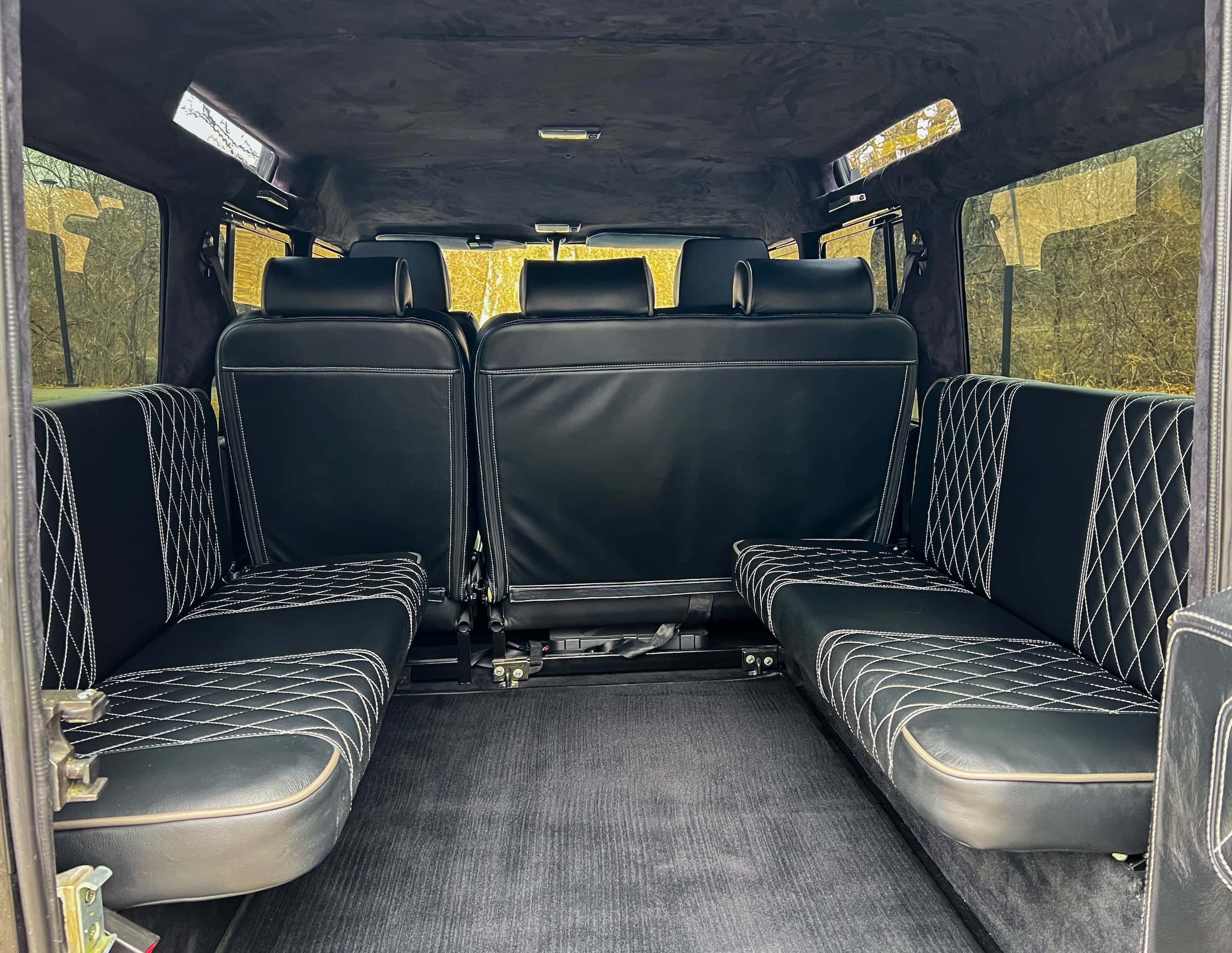 Interior view of a luxury Land Rover Defender with black quilted leather seating