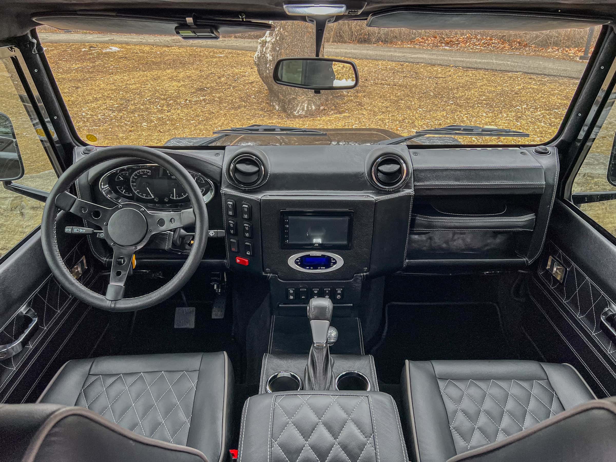 Bespoke Land Rover Defender interior featuring premium black leather seats and modern dashboard