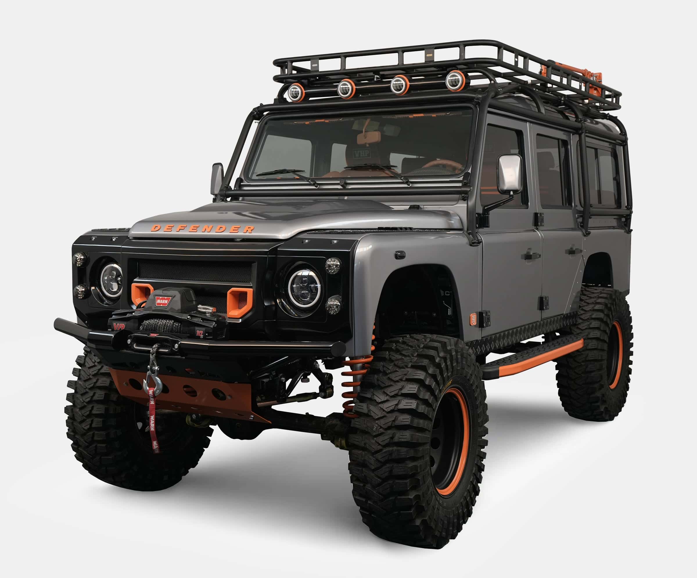 Front view of a bespoke Land Rover Defender with gray exterior and orange accents