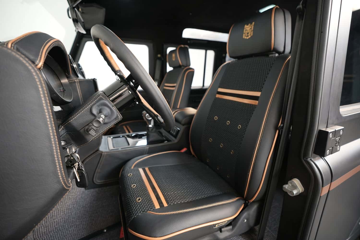 Custom Land Rover Defender interior with premium black leather seats and orange stitching