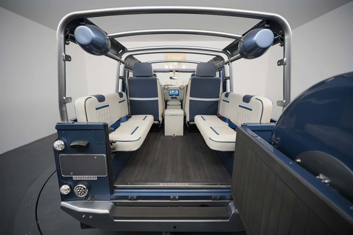 Interior view of a custom Land Rover Defender featuring blue and cream leather seats with a modern dashboard