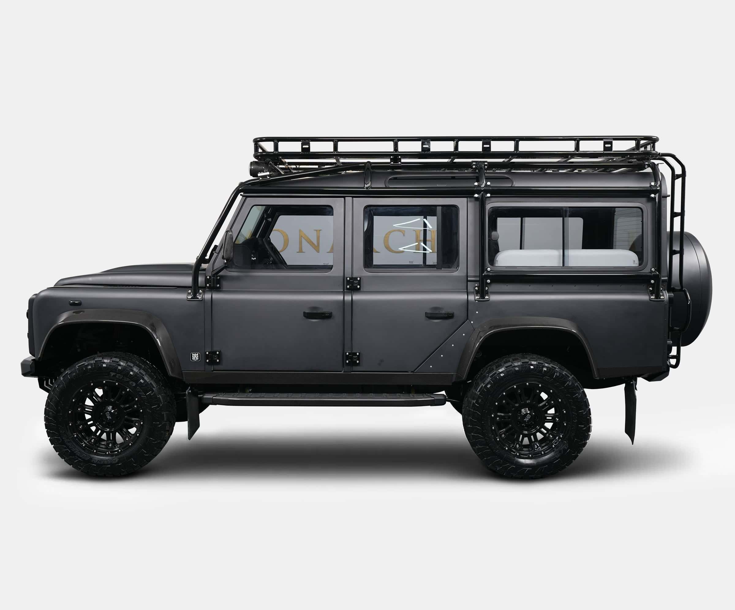 Side view of a bespoke Land Rover Defender with a matte black finish and rugged off-road tires
