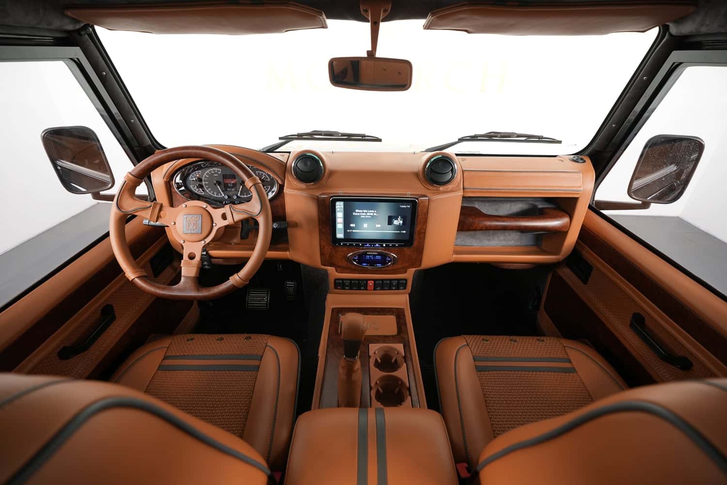 Interior view of a custom Land Rover Defender showcasing premium leather seats and advanced technology
