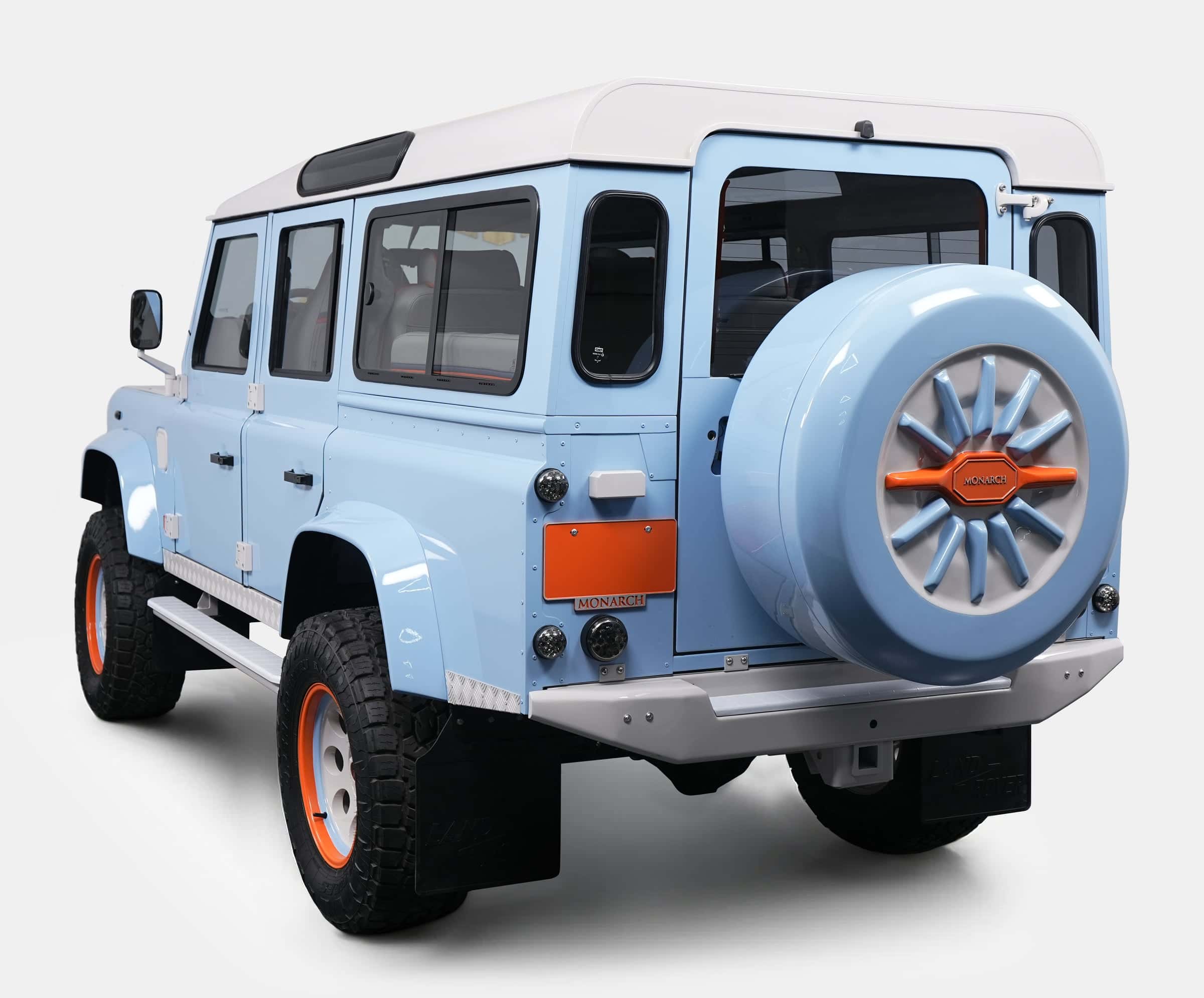Rear view of a bespoke Land Rover Defender in light blue with orange accents