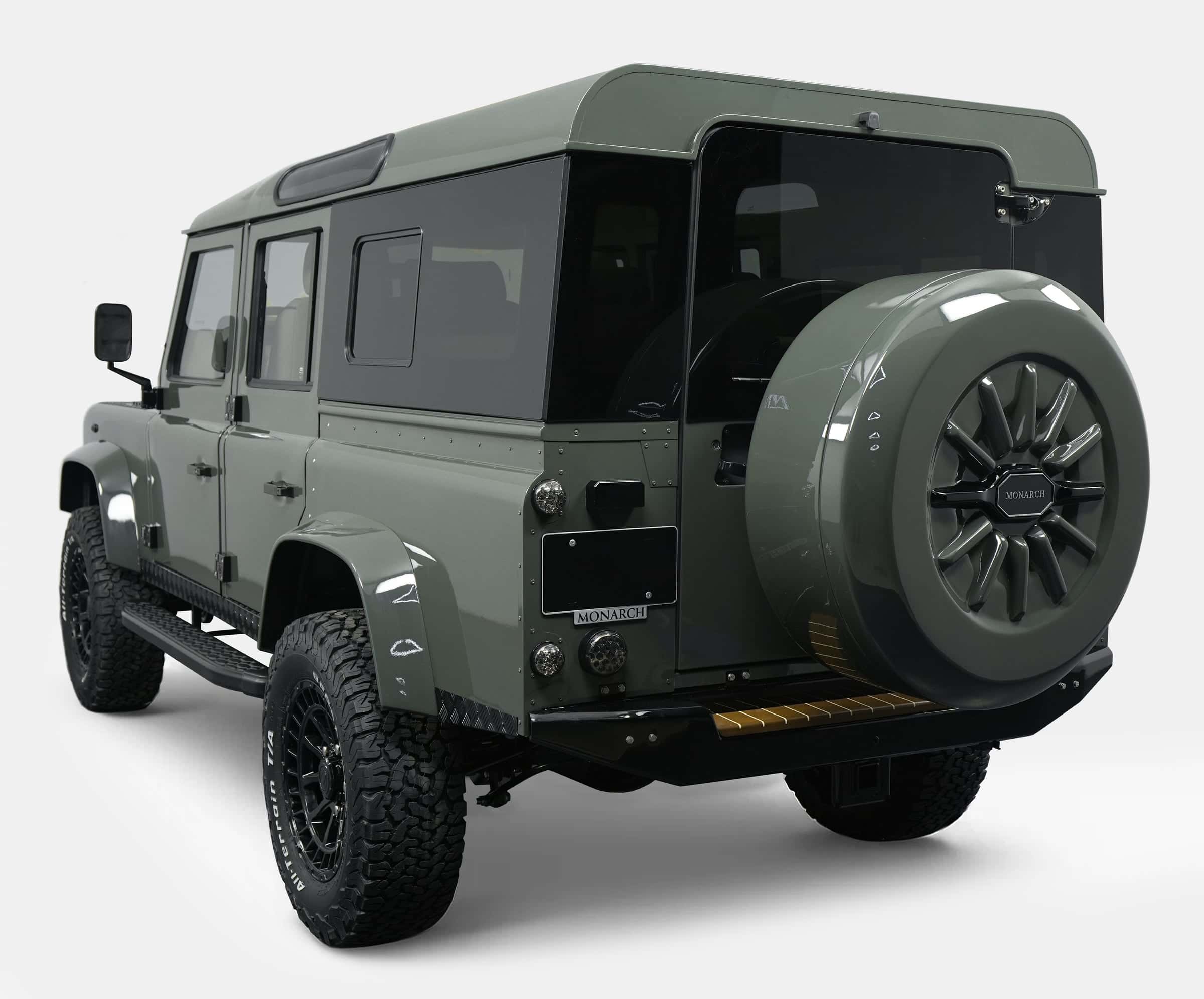 Rear view of a custom Land Rover Defender in green with premium off-road tires