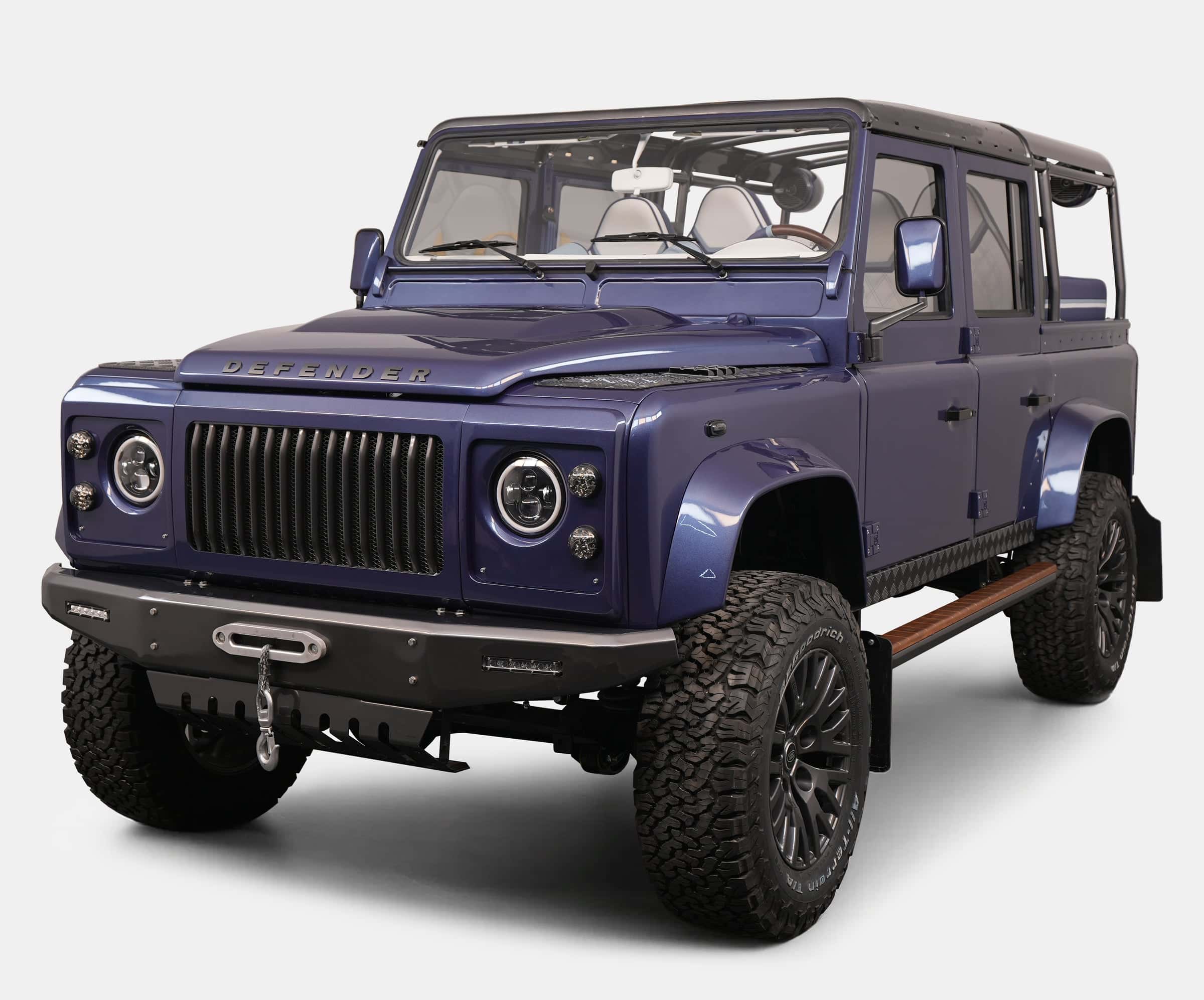 Custom Land Rover Defender in striking blue color with rugged tires and modern design features