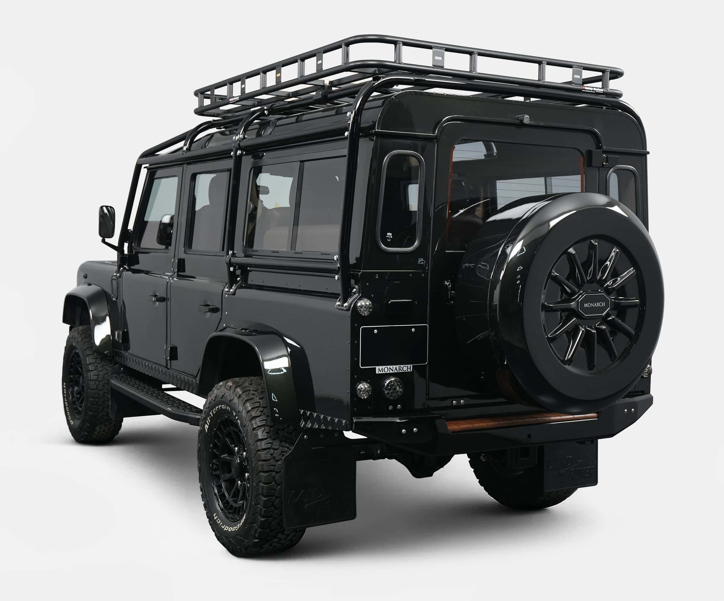 Black custom Land Rover Defender with roof rack and stylish rear design