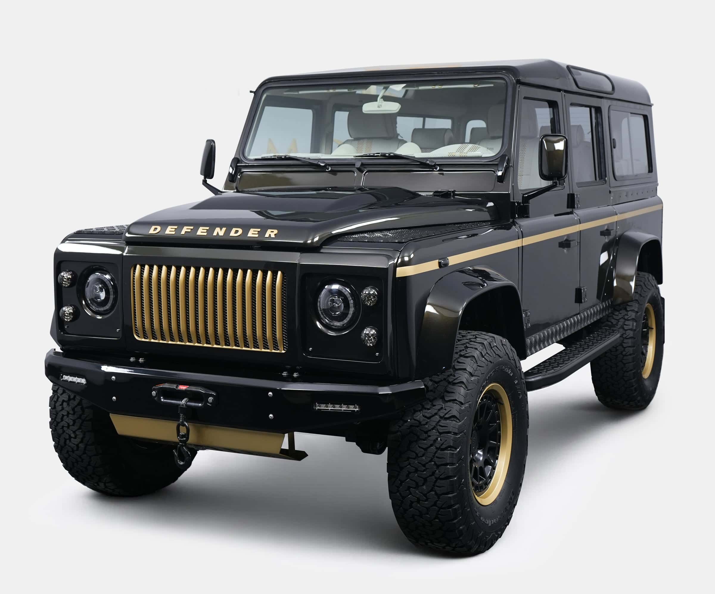 Custom black Land Rover Defender with gold accents and bold grille