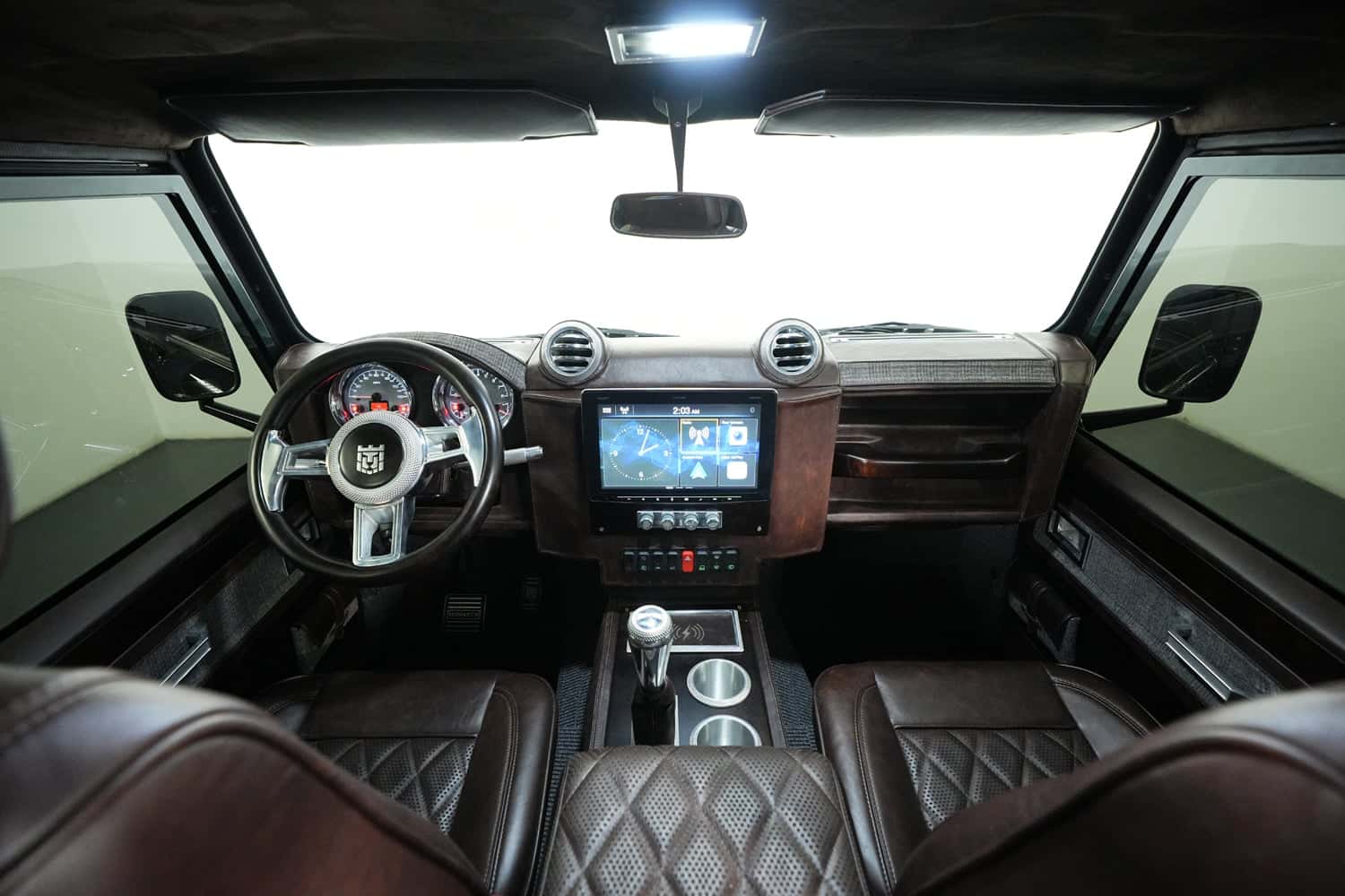 Interior view of a custom Land Rover Defender showcasing premium leather seats and advanced dashboard features