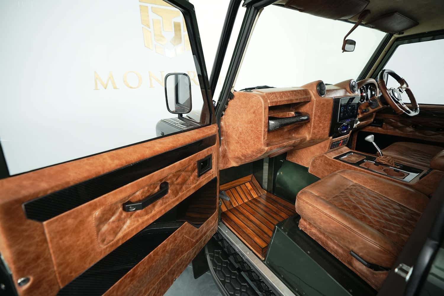 Interior view of a bespoke Land Rover Defender showcasing premium leather and wood finishes