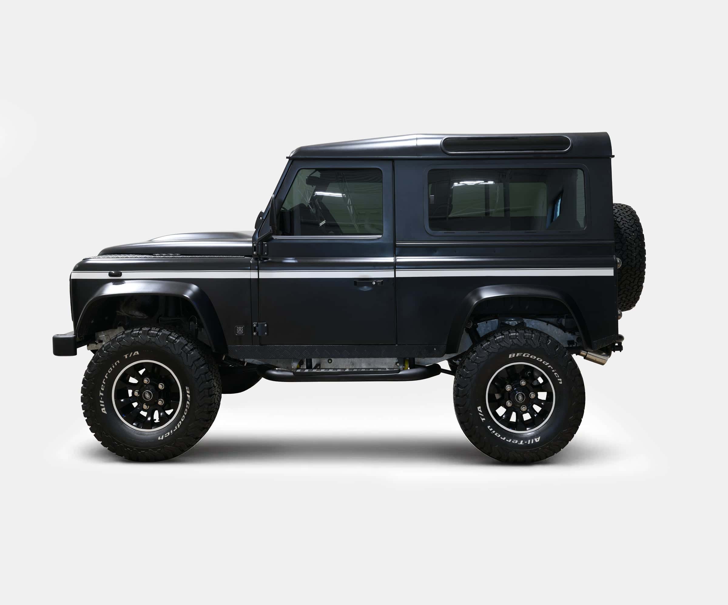 Custom Land Rover Defender in sleek black finish with off-road tires