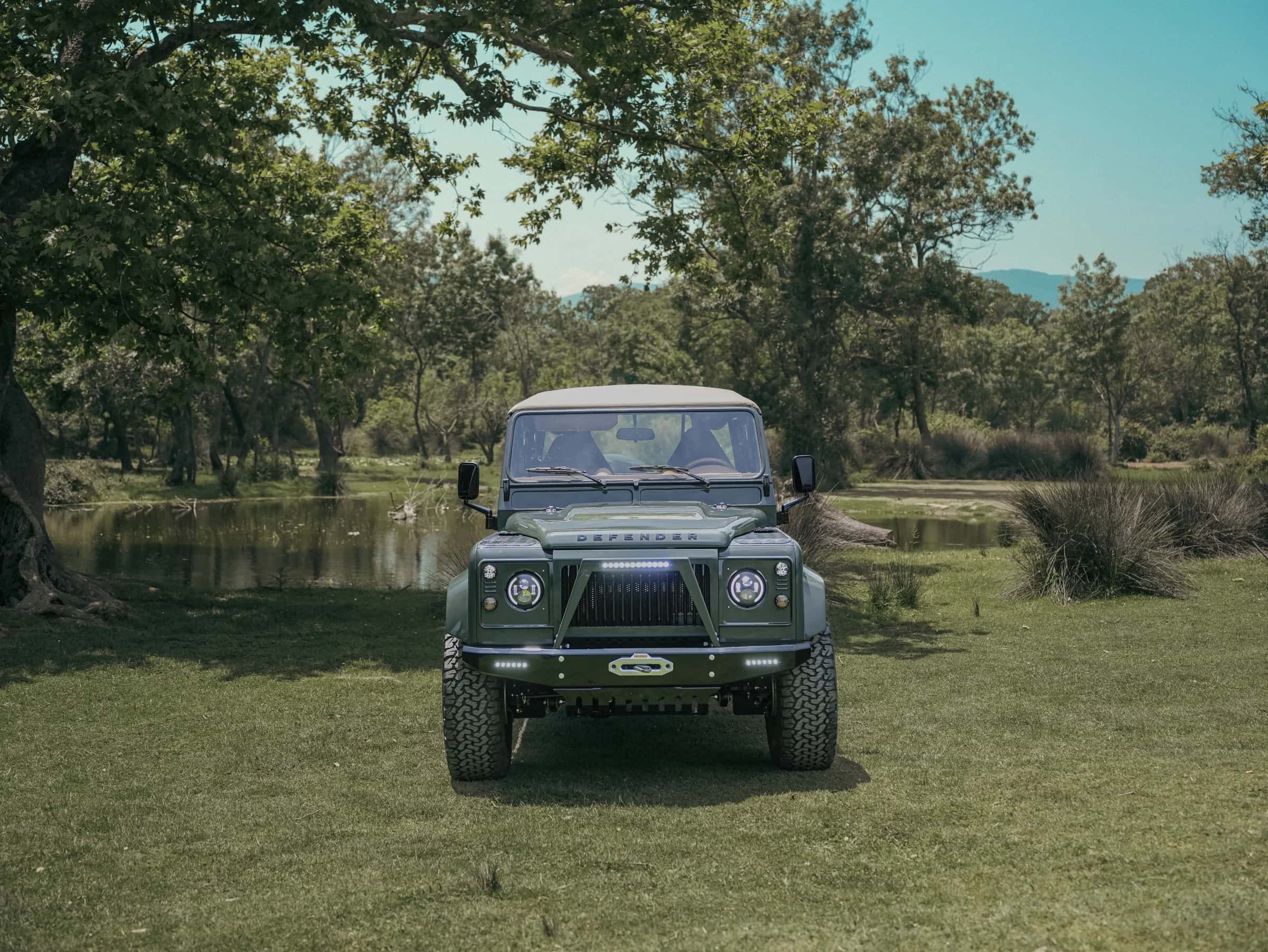 Front view of a custom Land Rover Defender in a natural setting