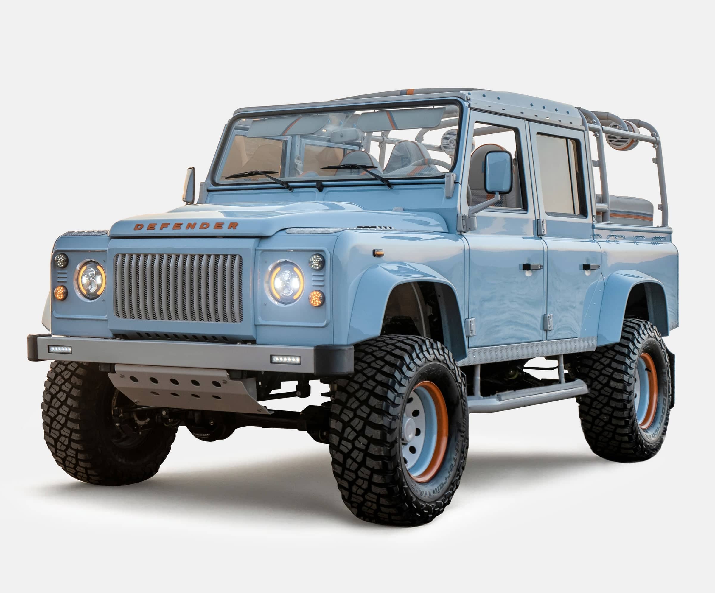 Front view of a custom Land Rover Defender in light blue with rugged off-road tires