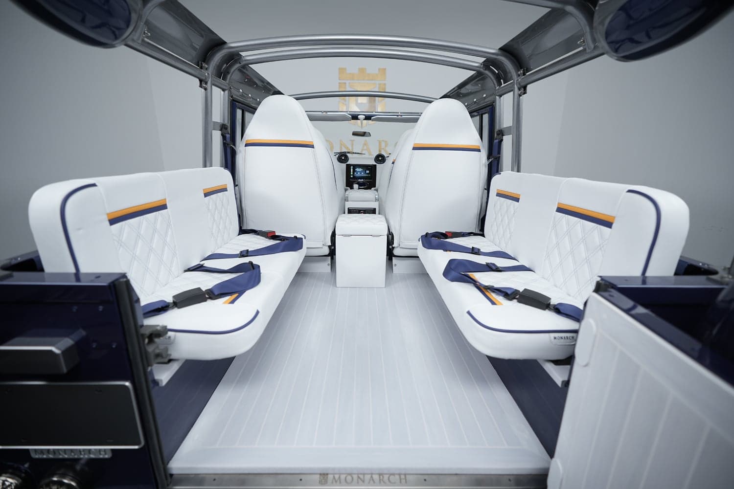 Interior of a custom Land Rover Defender featuring white leather seats with diamond stitching and blue accents