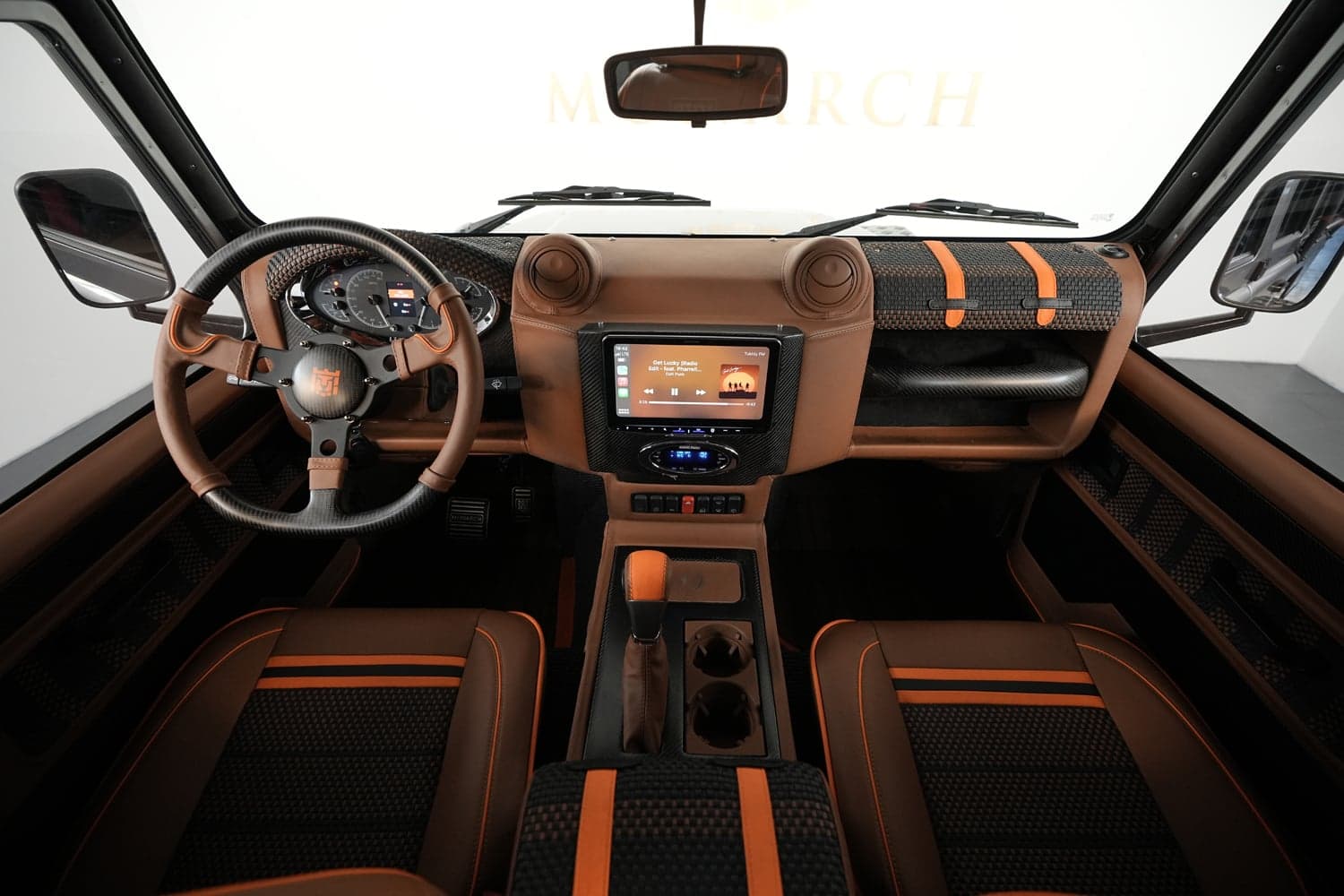 Luxury custom Land Rover Defender interior with brown and orange accents