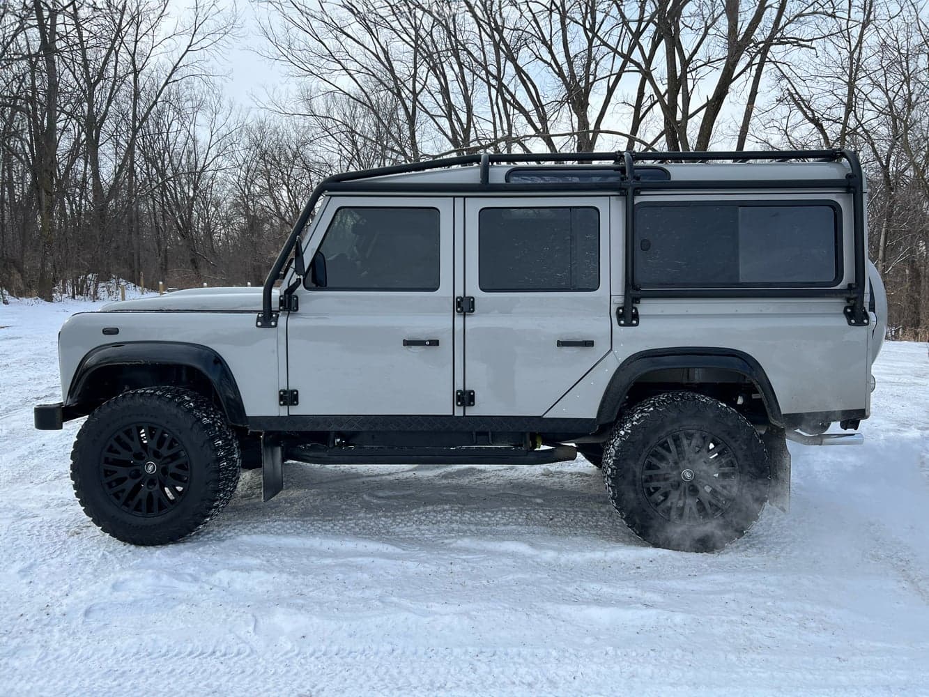 Side view of a bespoke Land Rover Defender parked on snow