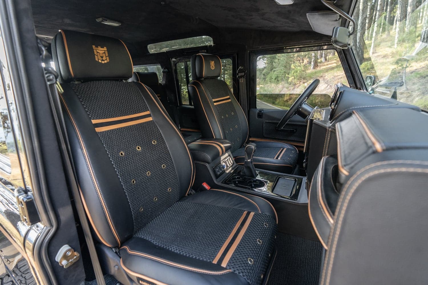 Bespoke Land Rover Defender interior featuring custom leather seating with orange accents