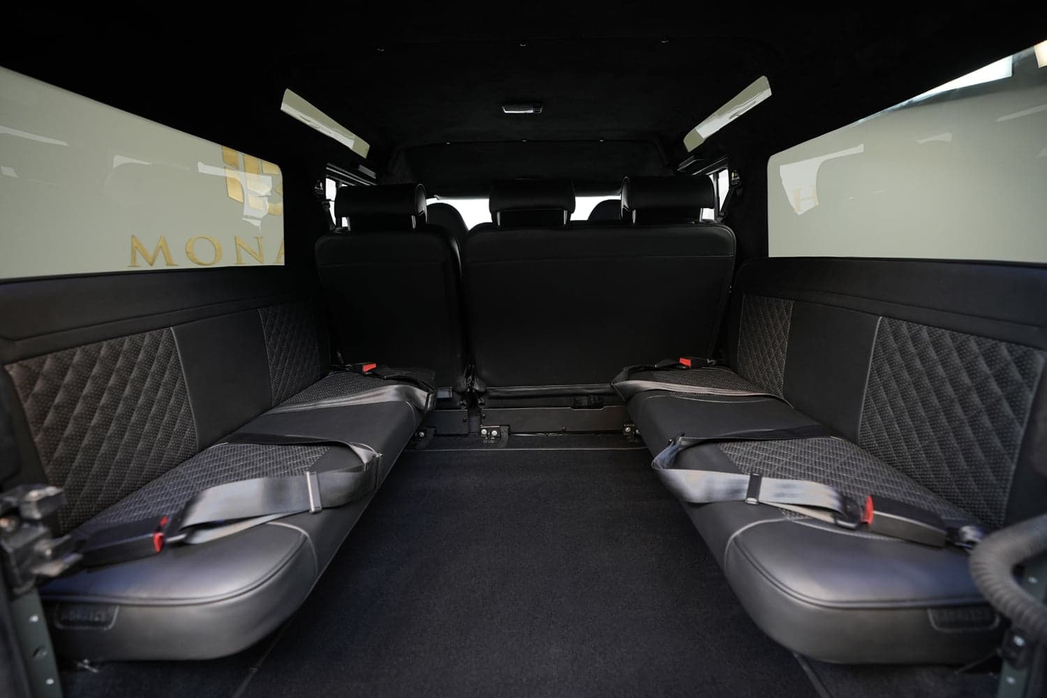Luxury rear seating of a bespoke Land Rover Defender with black leather and quilted detailing