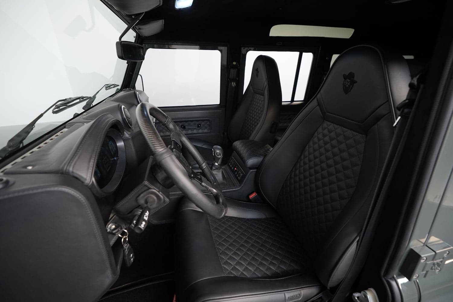 Luxury interior of a custom Land Rover Defender with black leather seats and detailed stitching