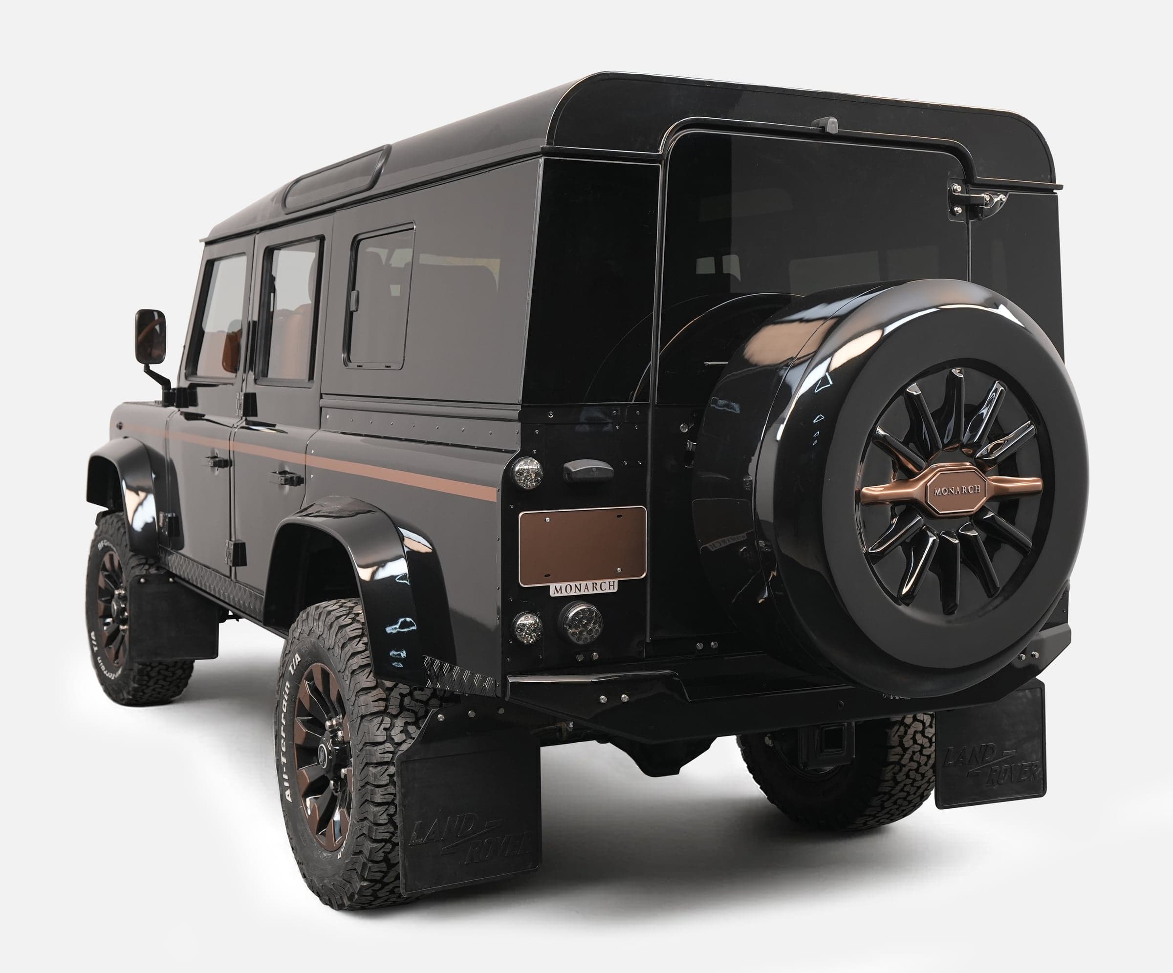 Customized black Land Rover Defender with unique styling and bronze accents