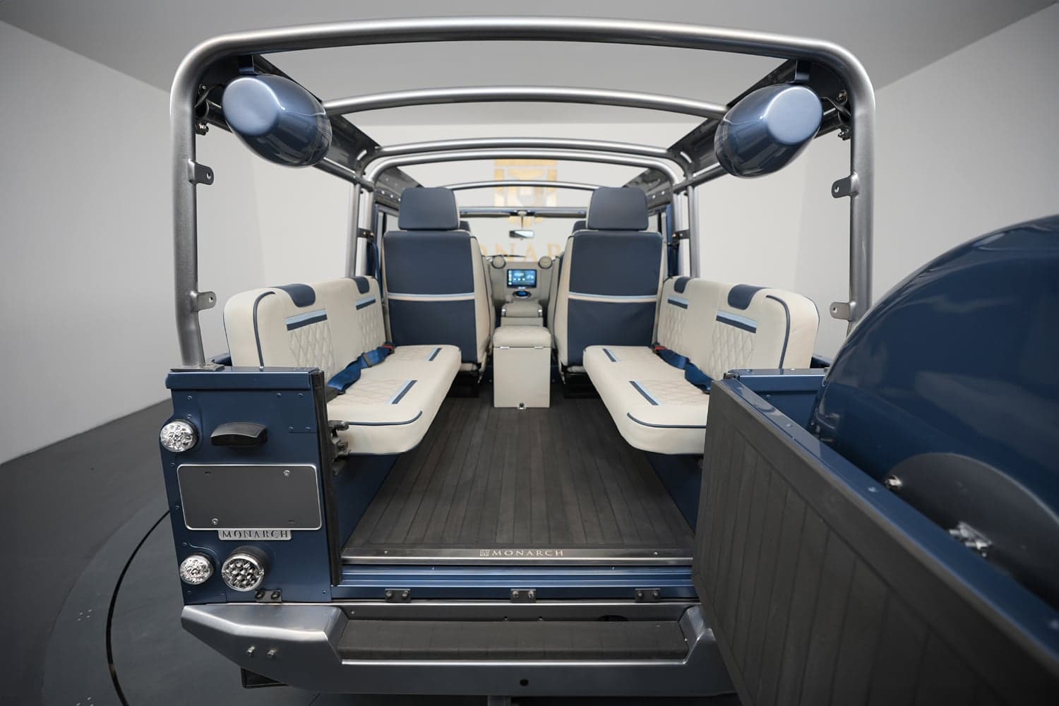 Interior view of a custom Land Rover Defender featuring blue and cream leather seats with a modern dashboard