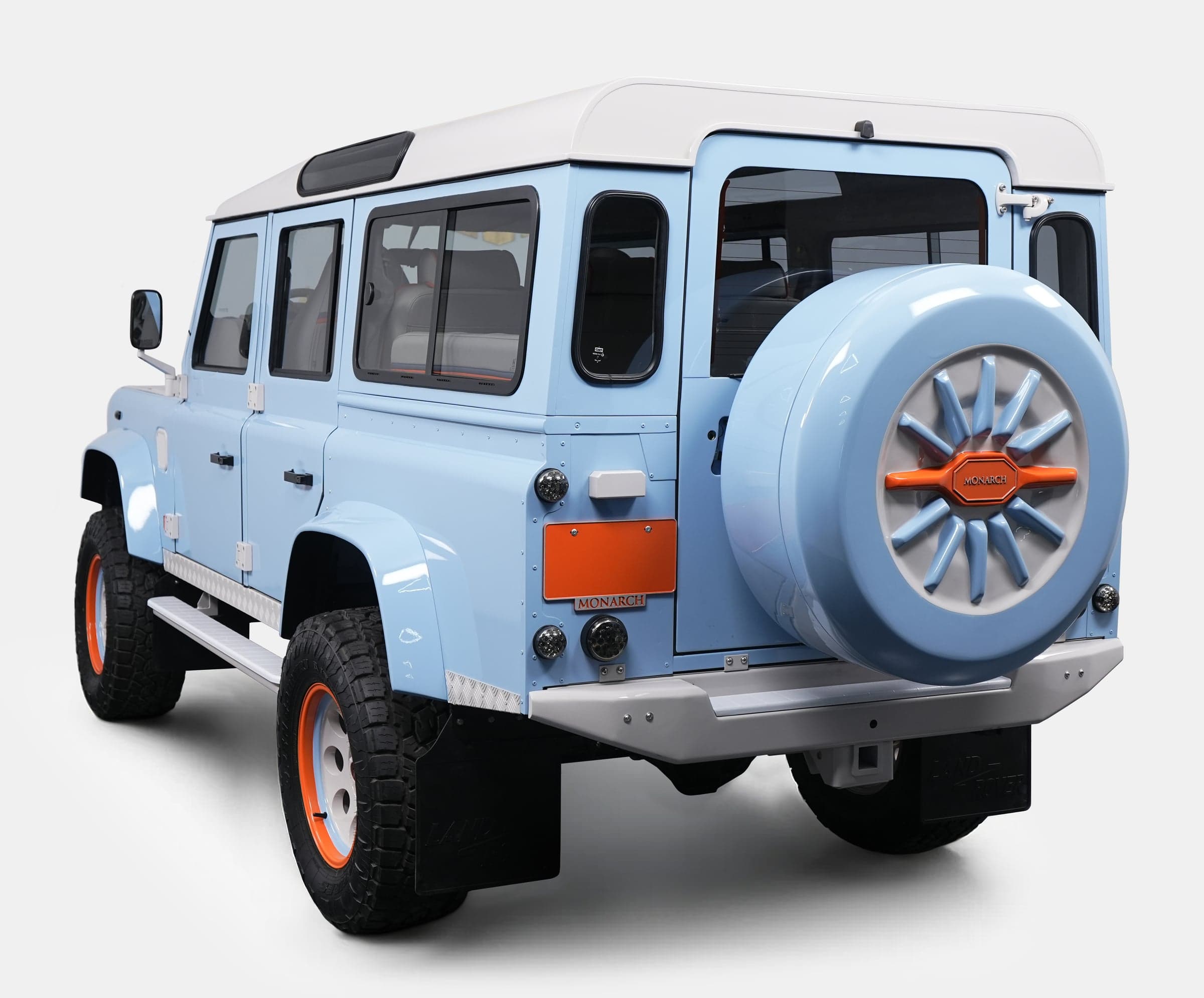 Rear view of a bespoke Land Rover Defender in light blue with orange accents