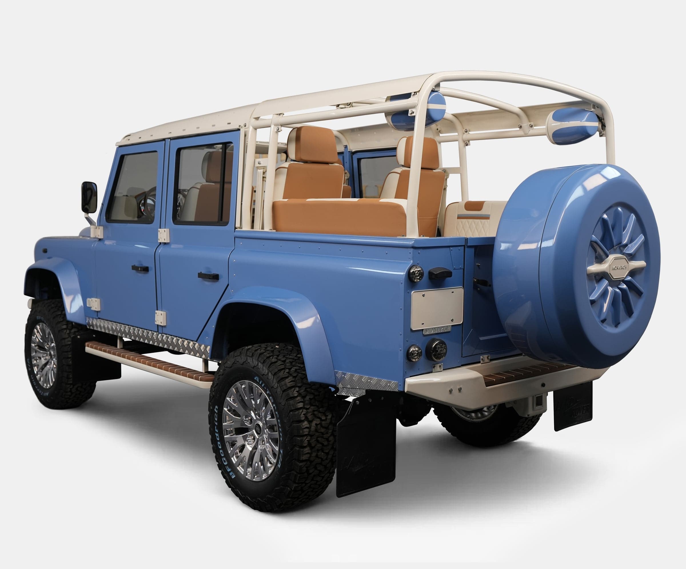 Custom blue Land Rover Defender with tan interior and chrome wheels