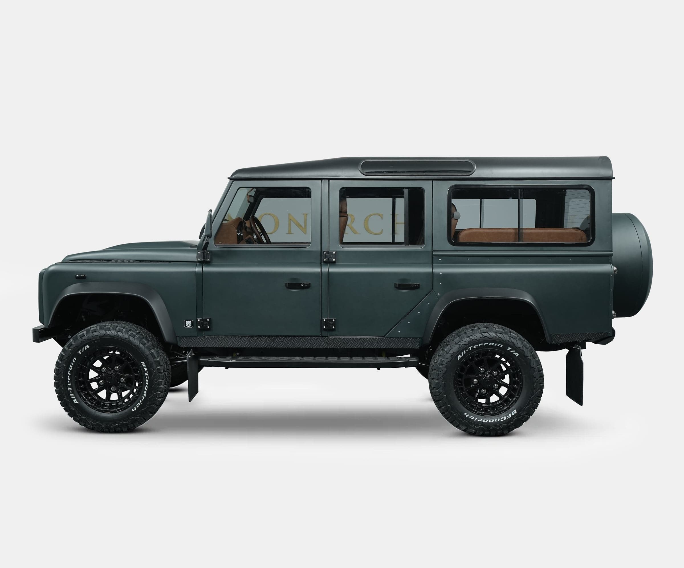 Custom Land Rover Defender in dark green with off-road tires