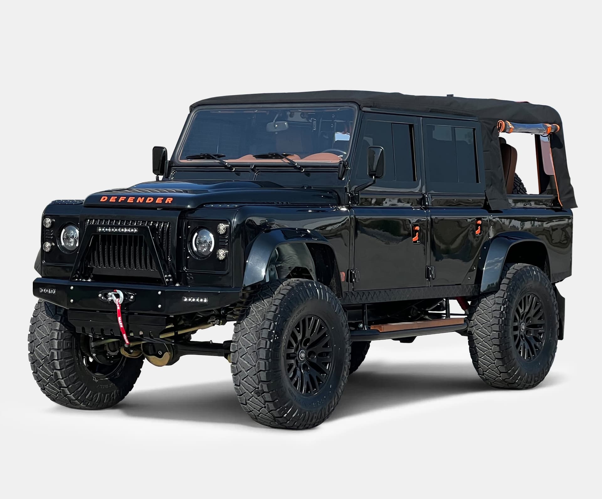 Front view of a custom black Land Rover Defender with luxury detailing and off-road tires