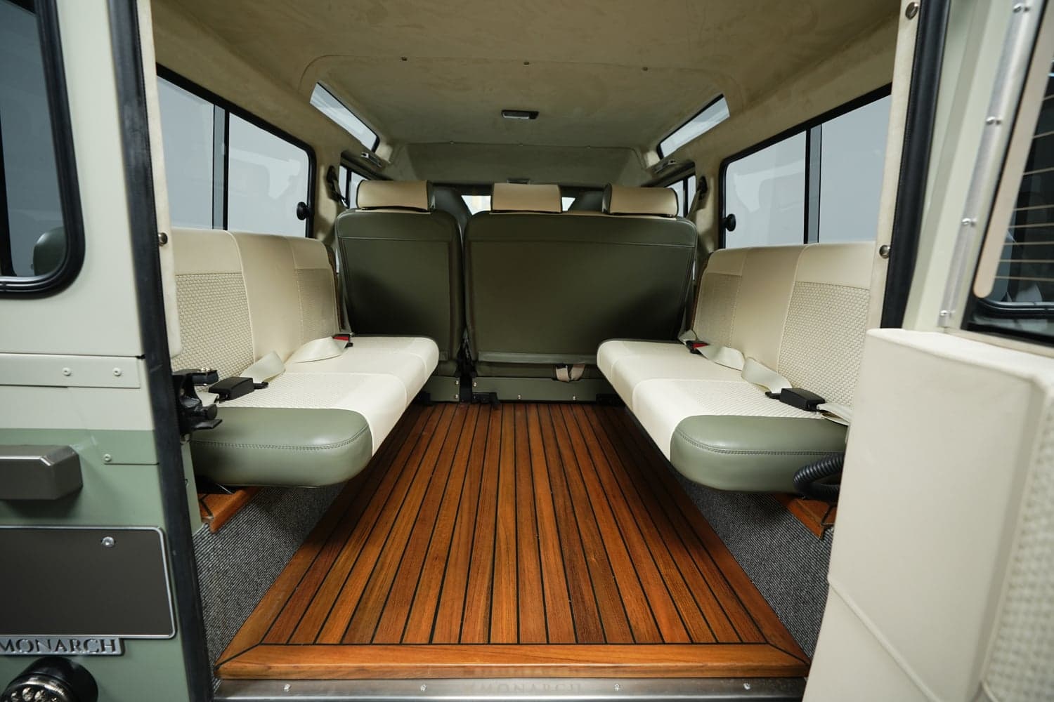 Interior view of a custom Land Rover Defender with premium seating and wooden flooring