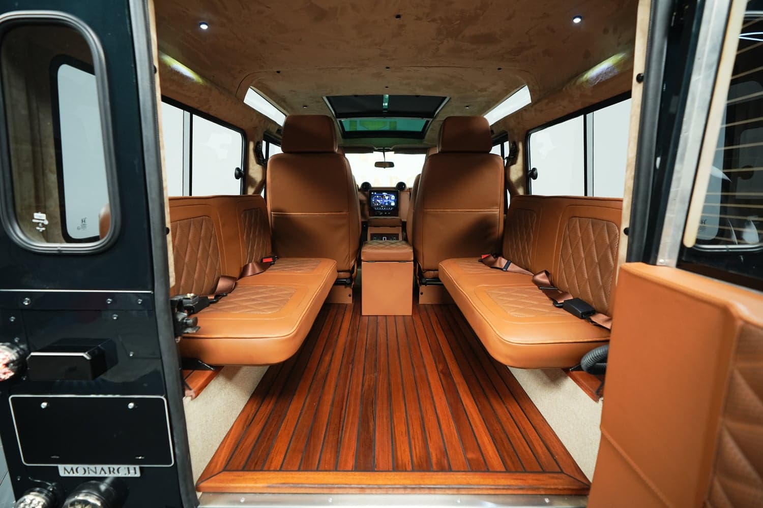 Bespoke Land Rover Defender interior with tan leather seating and wood flooring